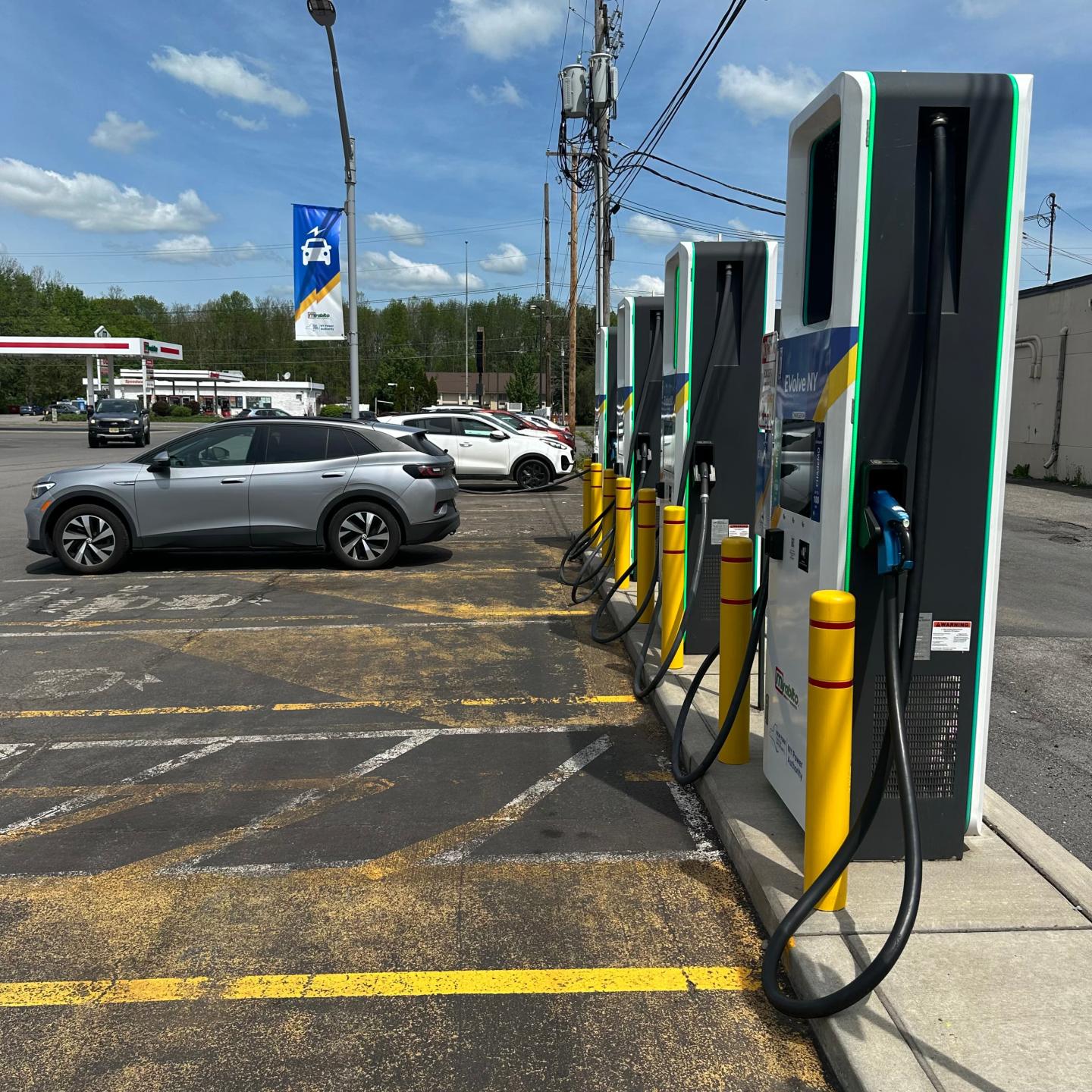 A row of EV chargers with cars parked nearby