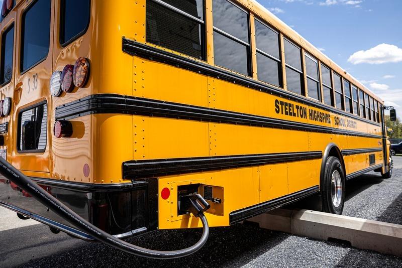 An electric school bus plugged in and charging