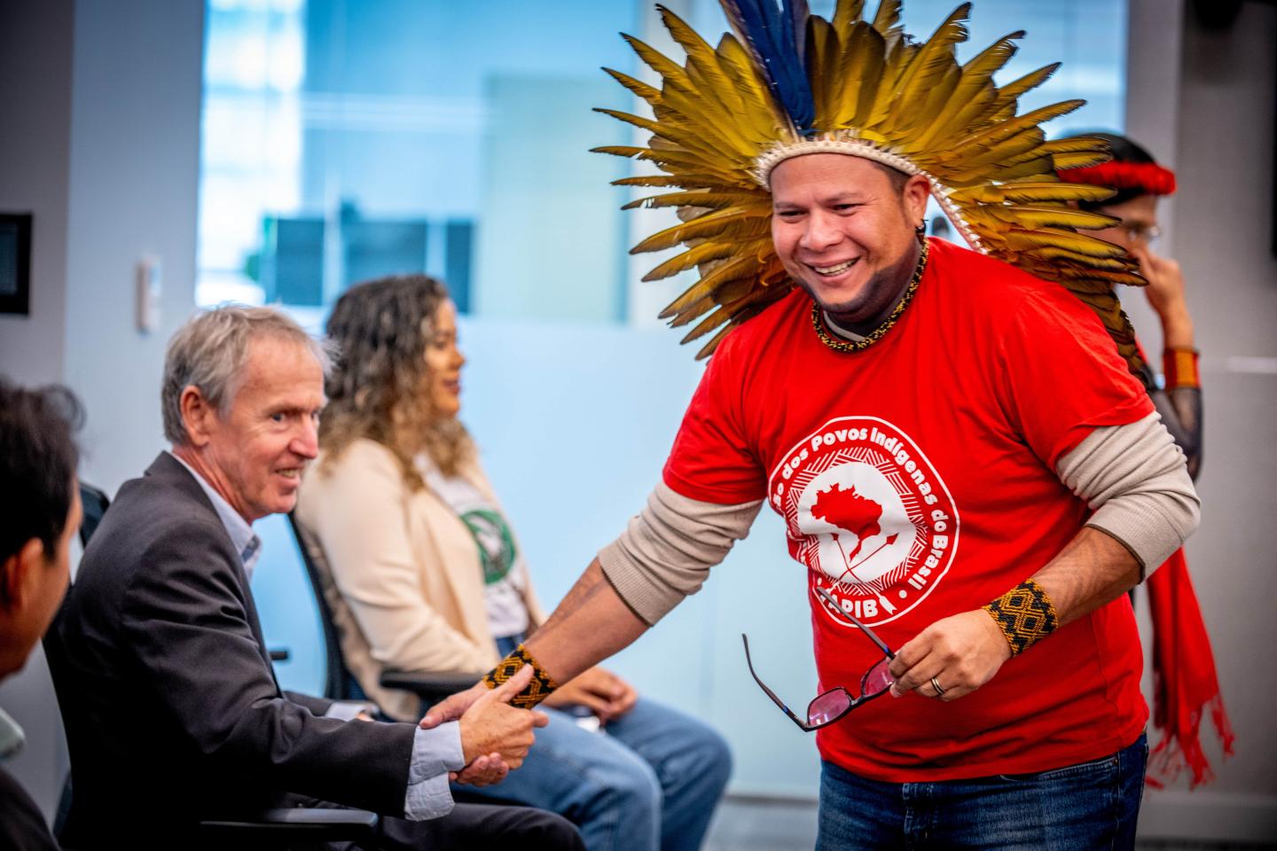 Kleber Karipuna shaking hands during a climate conference