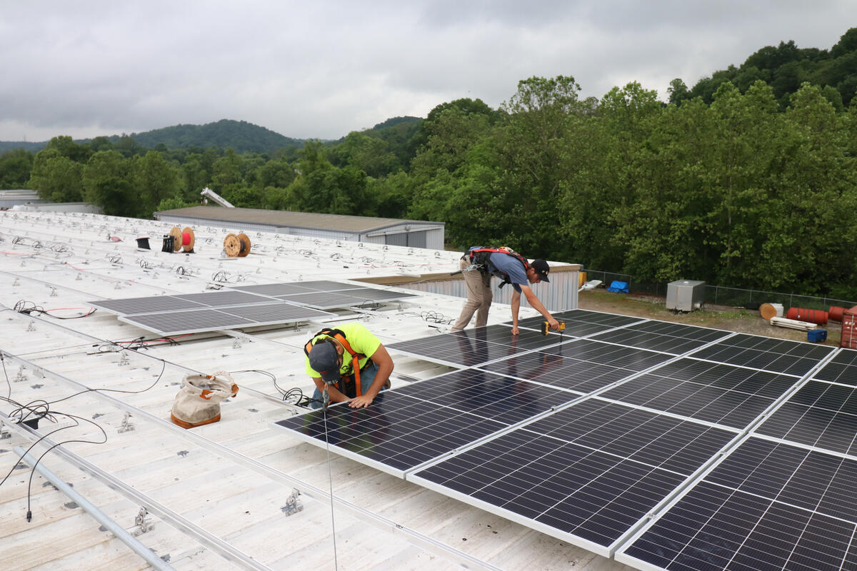 People installing solar panels on a rooftop