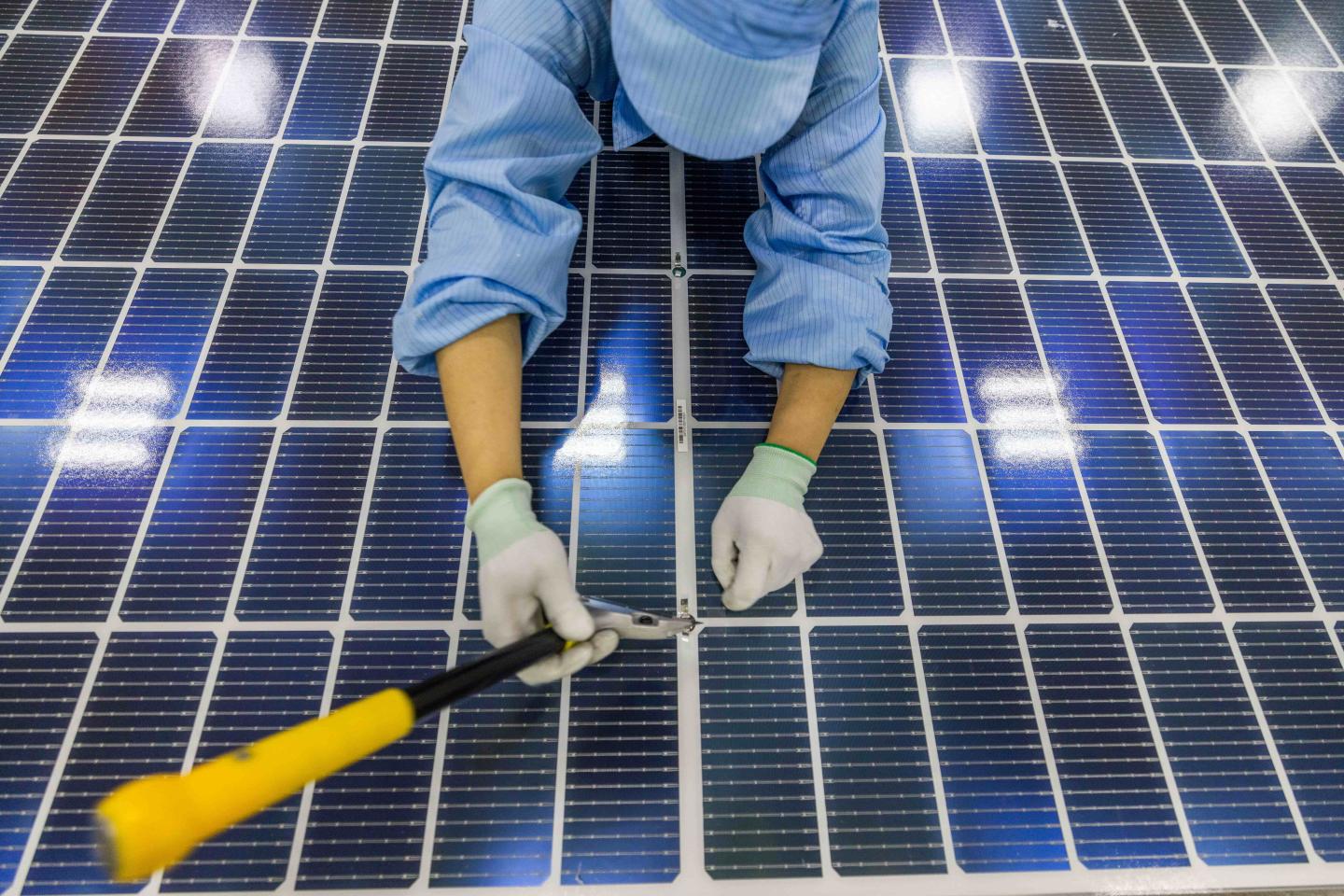 A worker putting finishing touches on a solar panel