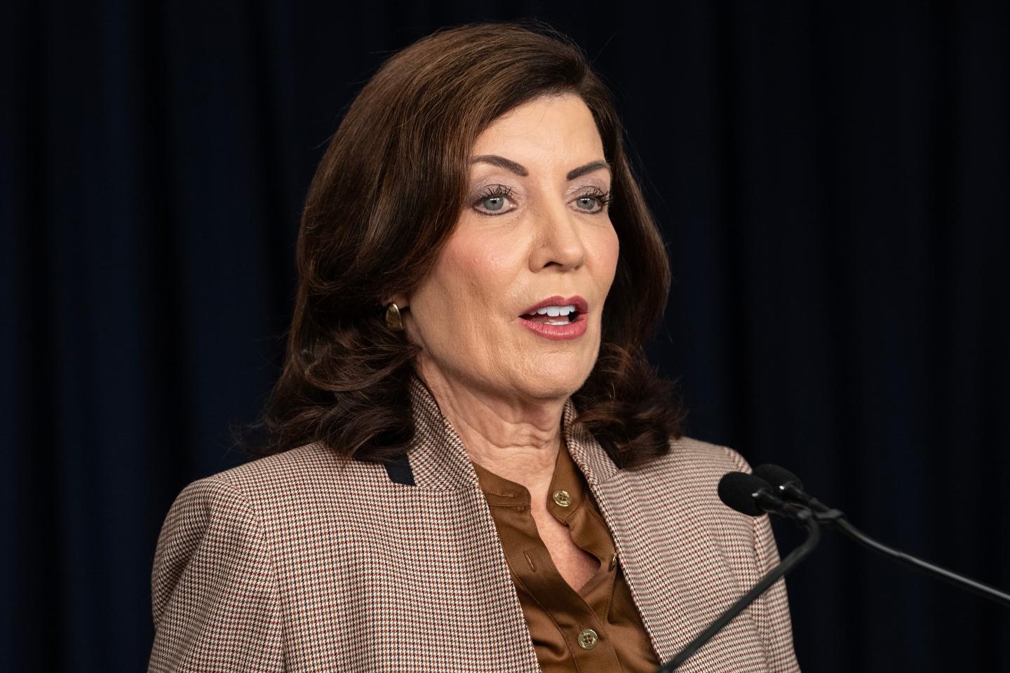 New York Governor Kathy Hochul standing in front of microphones