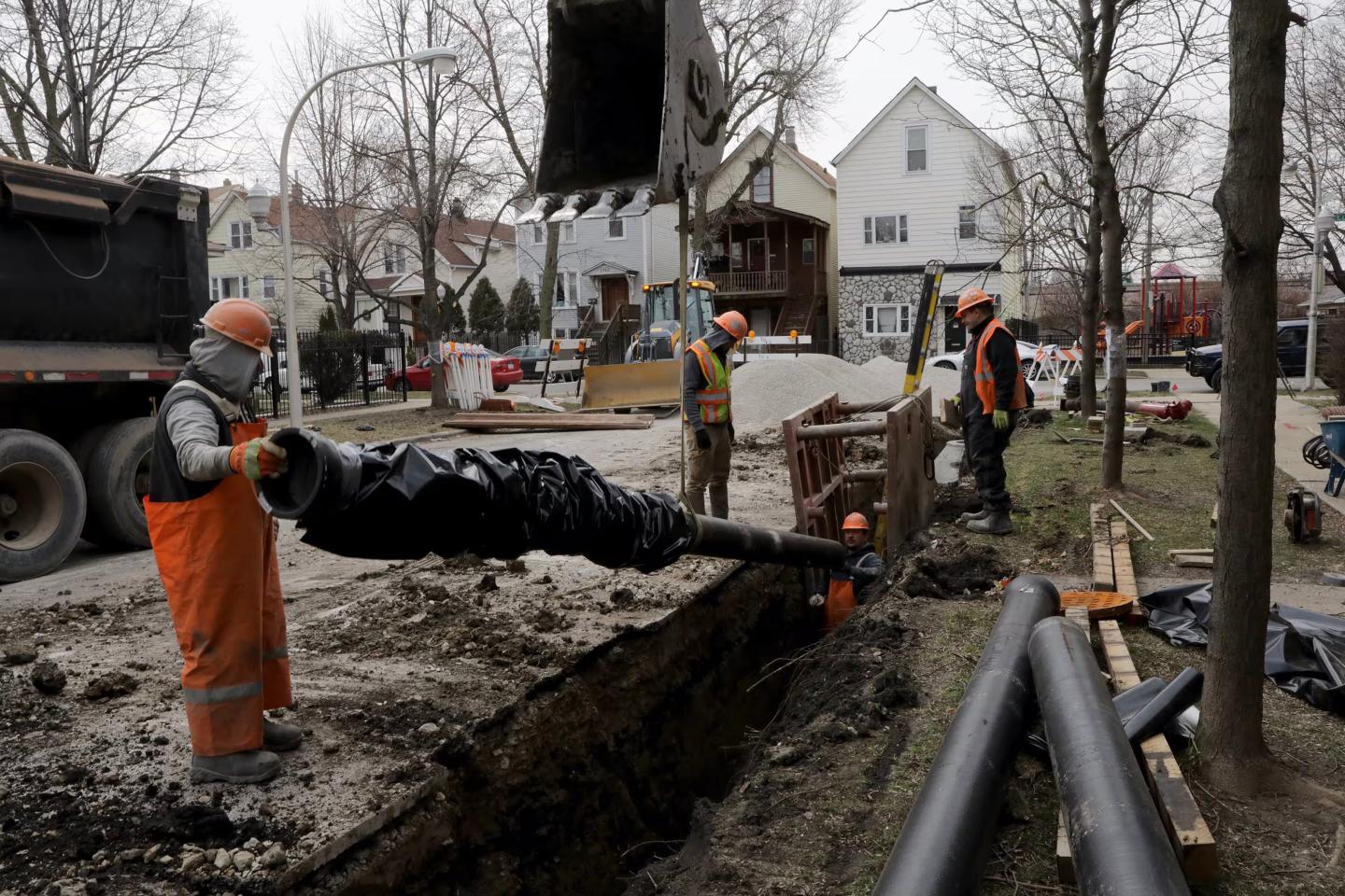 Workers installing new water pipes at street level