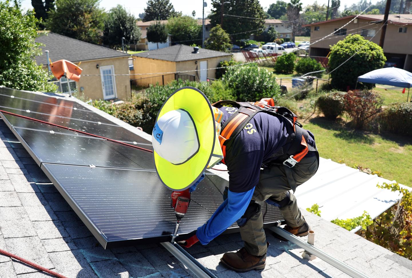 A worker installing solar panels on a roof