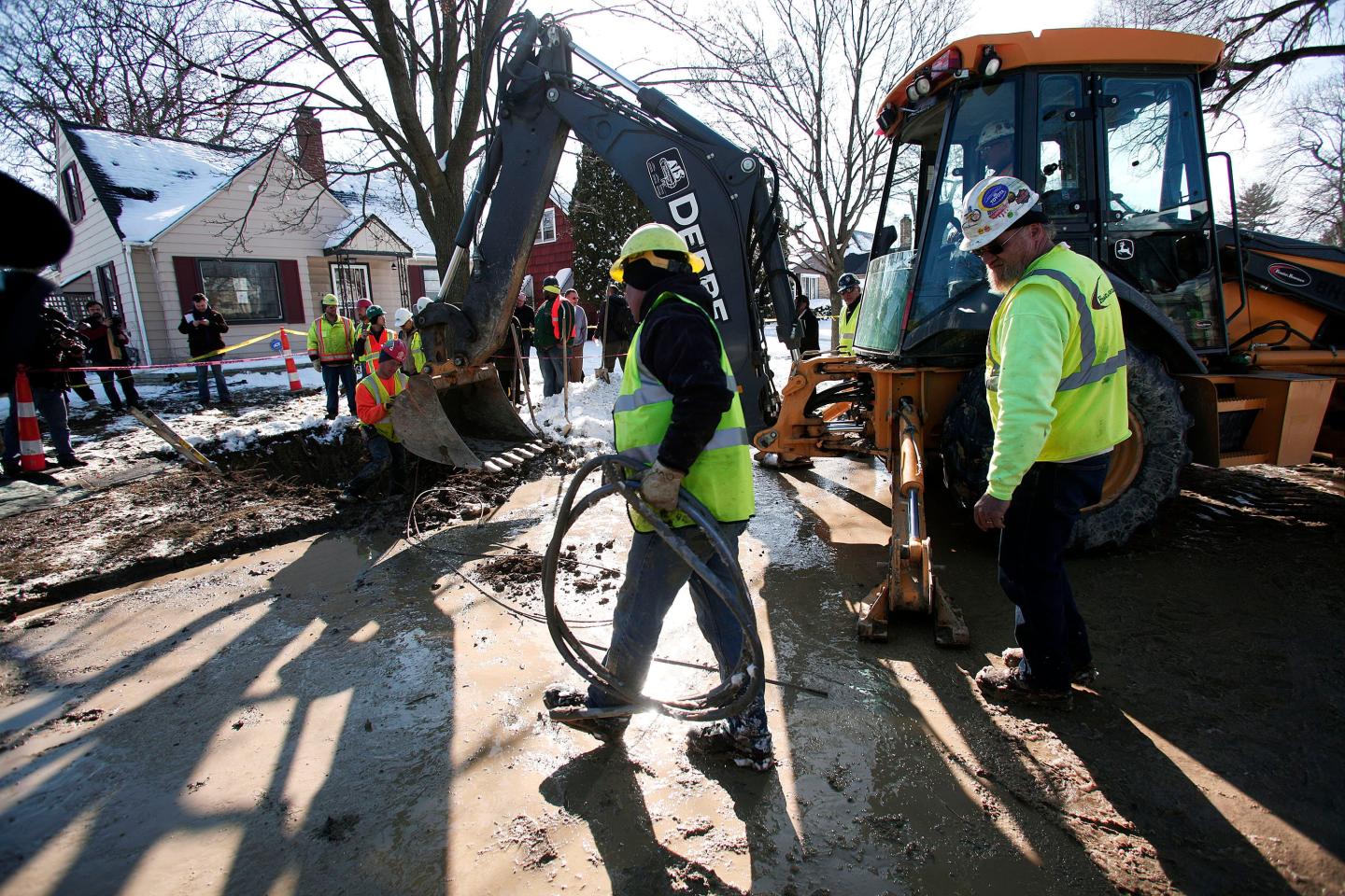 Utility workers replacing lead pipes along a street