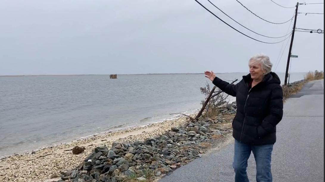 Maura Spery gestures to the water in Mastic Beach