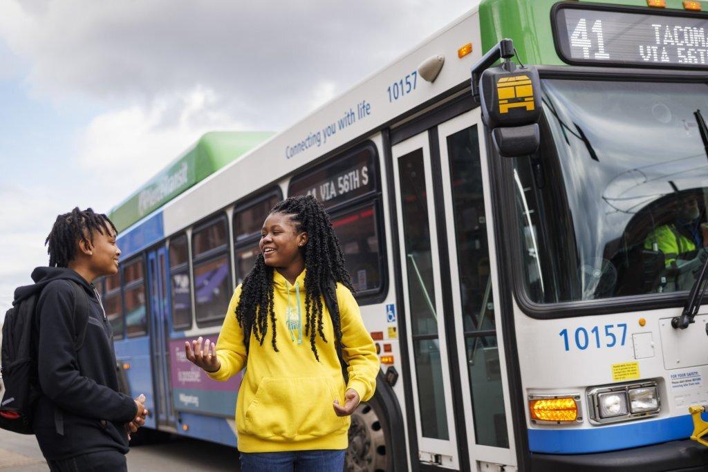 Two people about to board a city bus