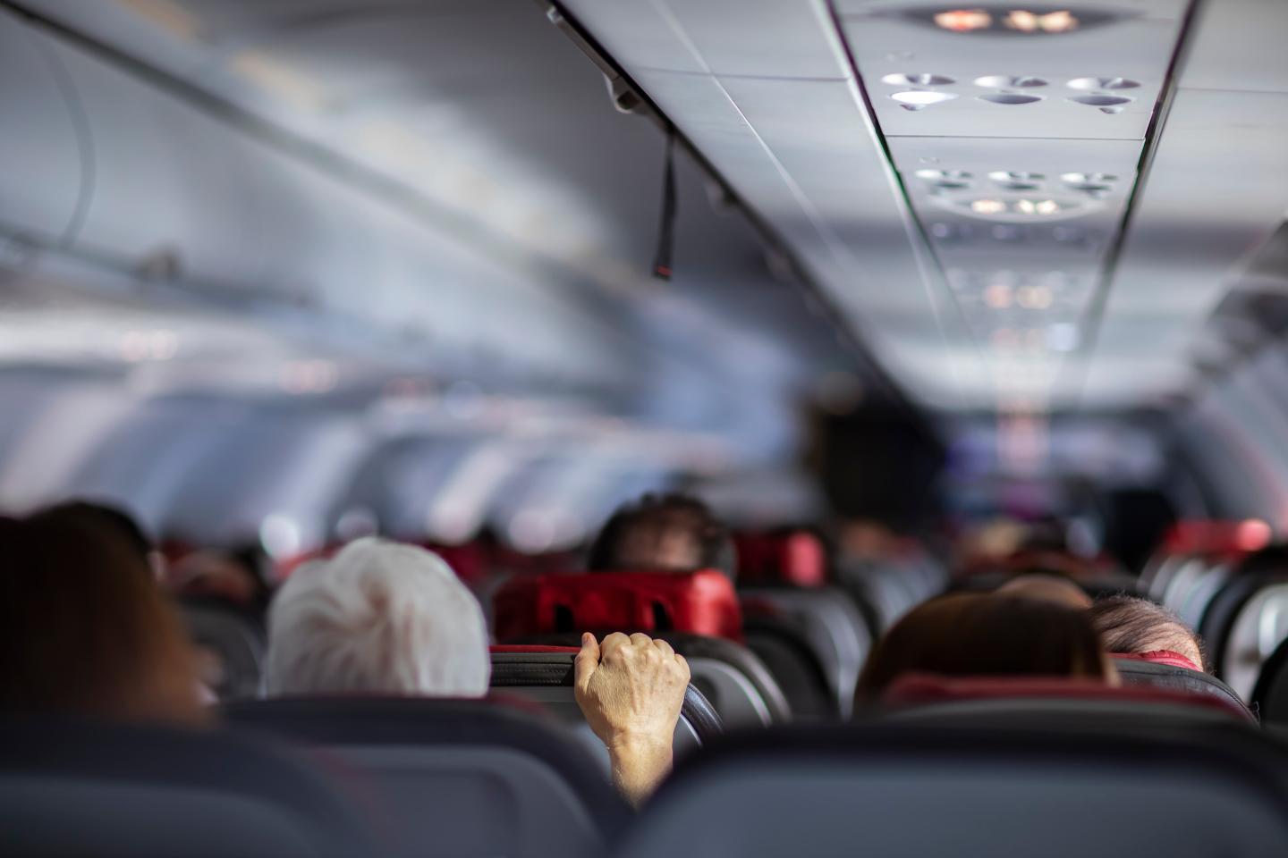 A person gripping a plane seat tightly