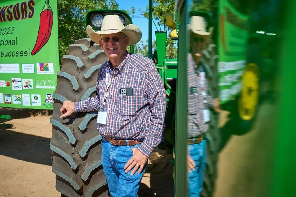 Ed Curry standing in front of a tractor wheel