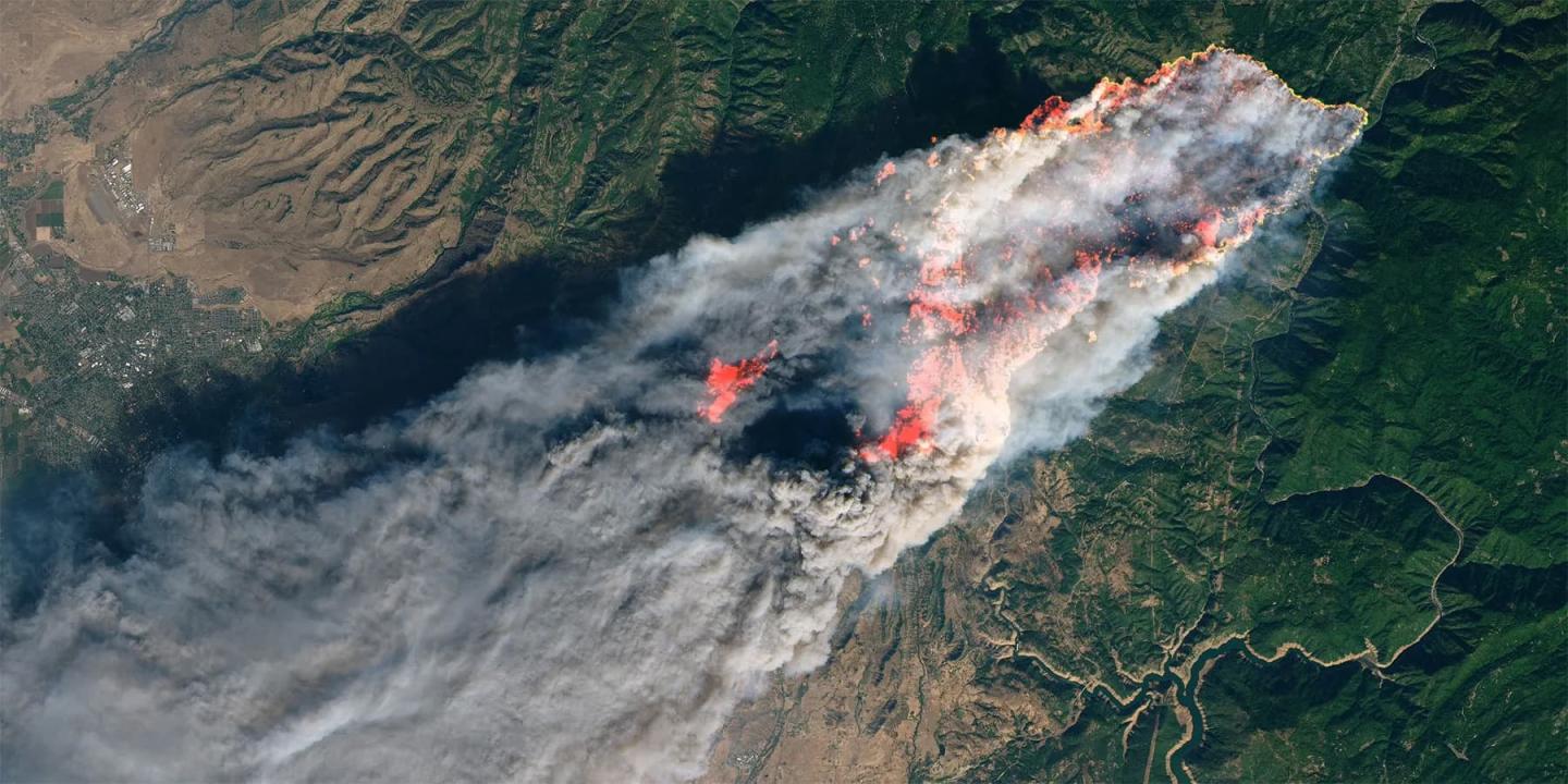 An aerial view of a spreading wildfire