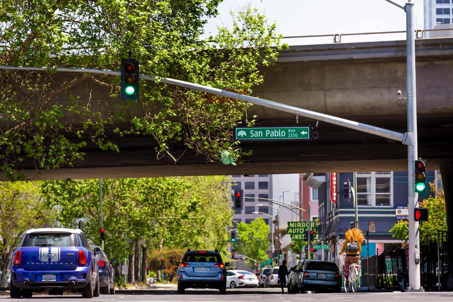 A street in Oakland, California with green trees lining the road