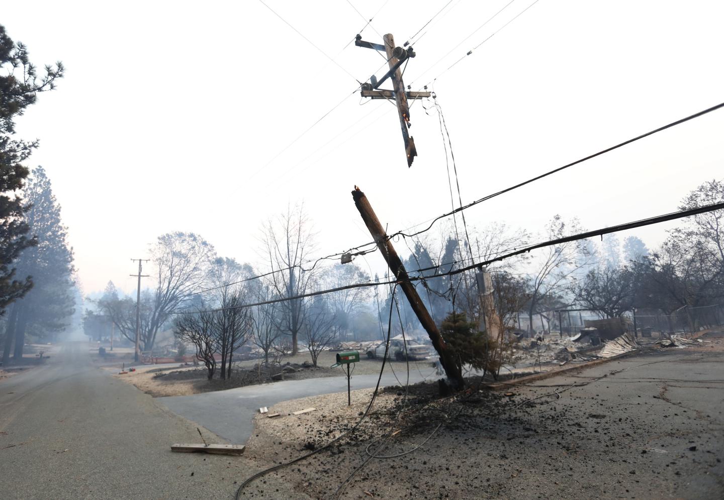 An electrical pole that has caught fire and split in half