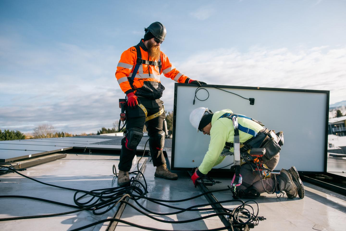 Two people installing solar panels