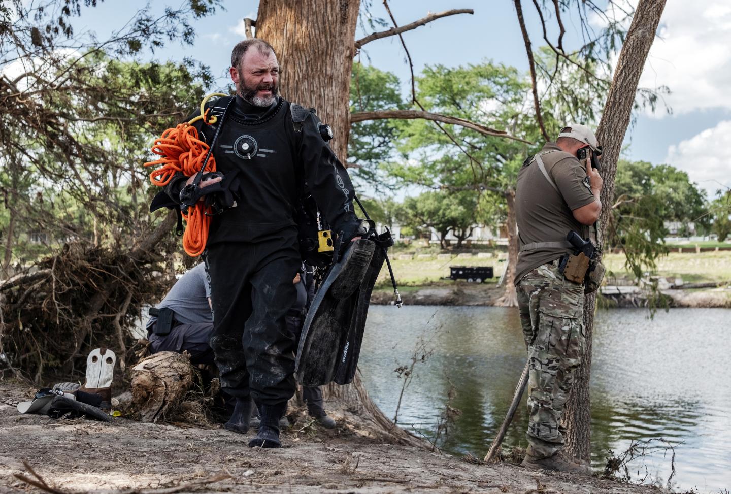 Exhausted diver carrying flippers exits site of Texas floods