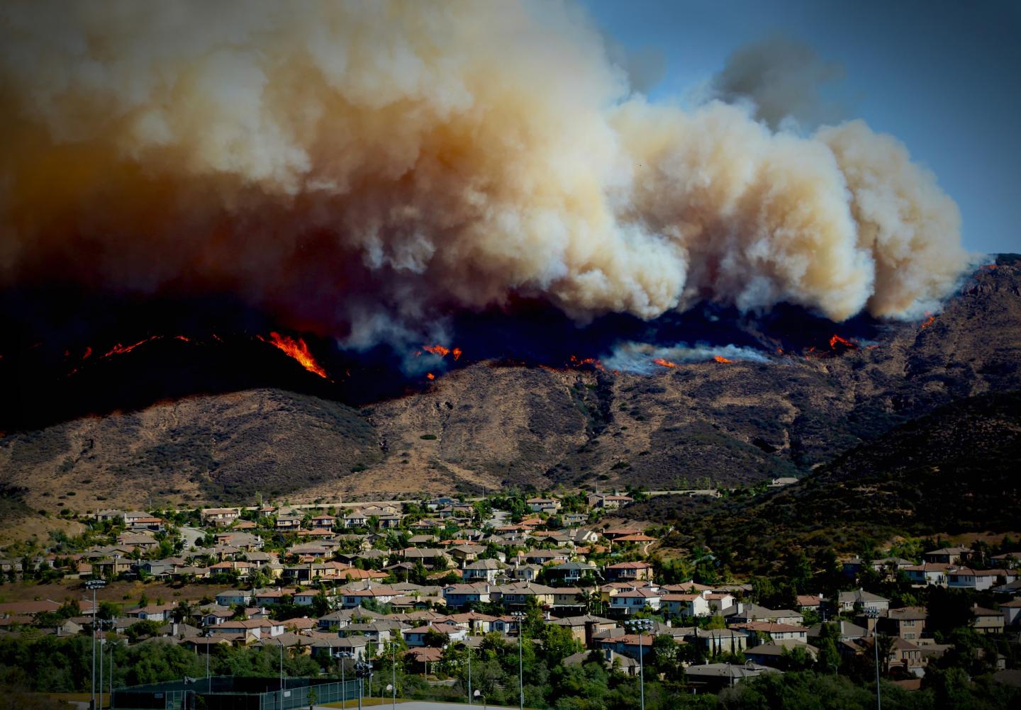 A wildfire coming over a ridge in Los Angeles