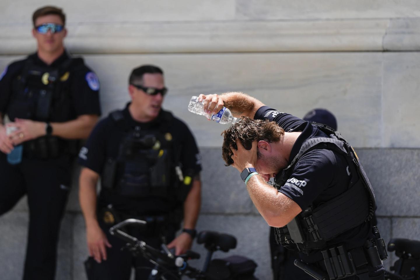 A police officer pours water over his head during DC heat wave