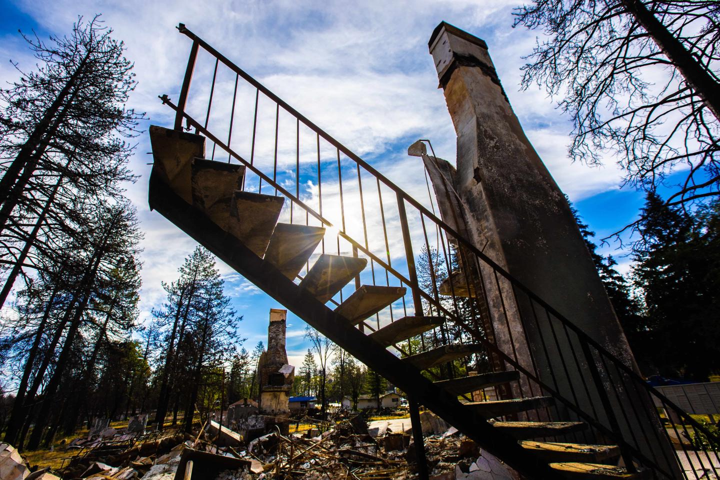 A home that has burned down from a wildfire with the staircase still standing