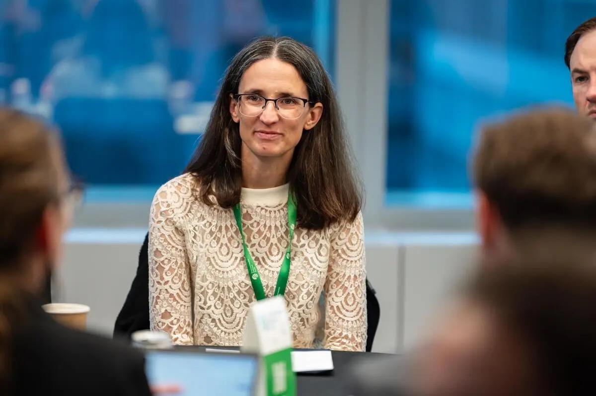 Carolyn Kousky sitting at a table during a conference