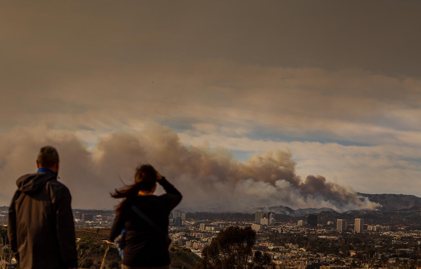 Two people looking at rolling wildfire smoke in the distance