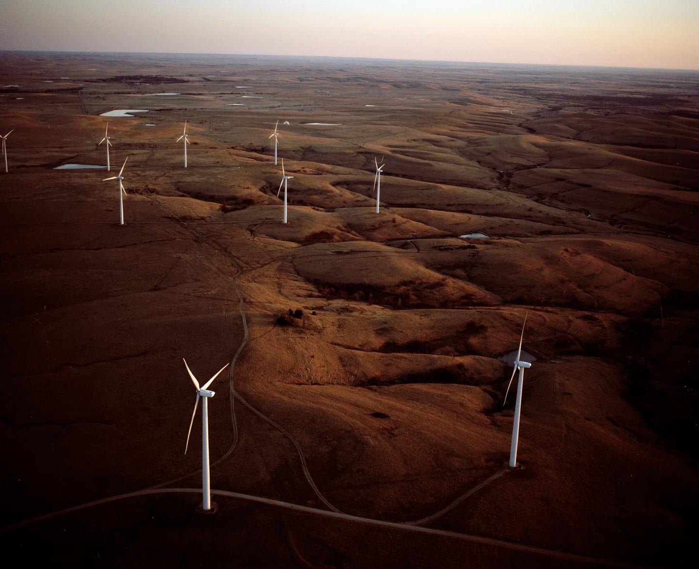 Wind turbines scattered across hilly terrain