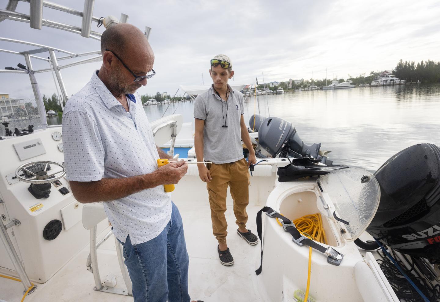 Alan Ralph Maria and his son standing on a fishing boat