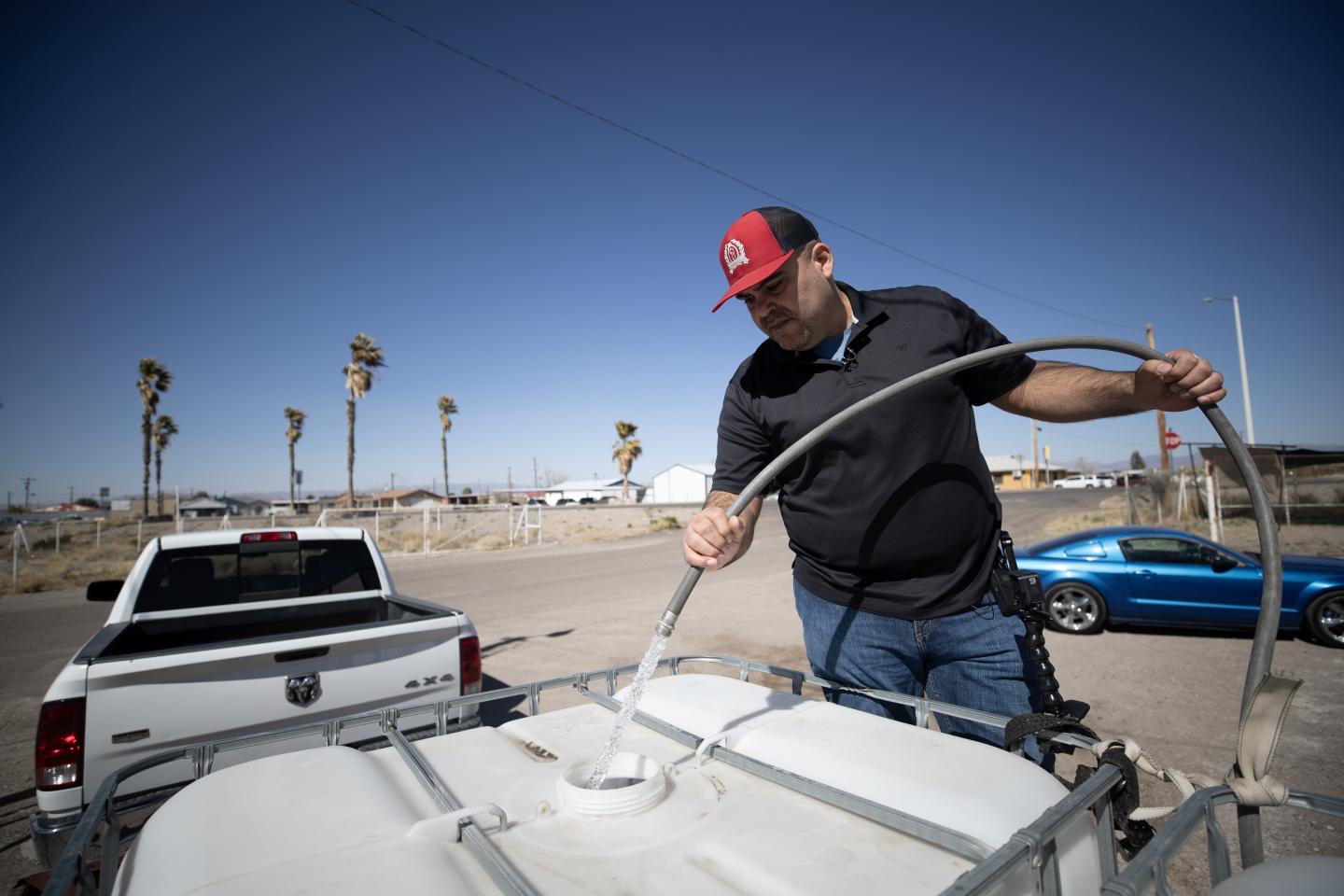 José Acosta filling up a tank of water attached to his truck
