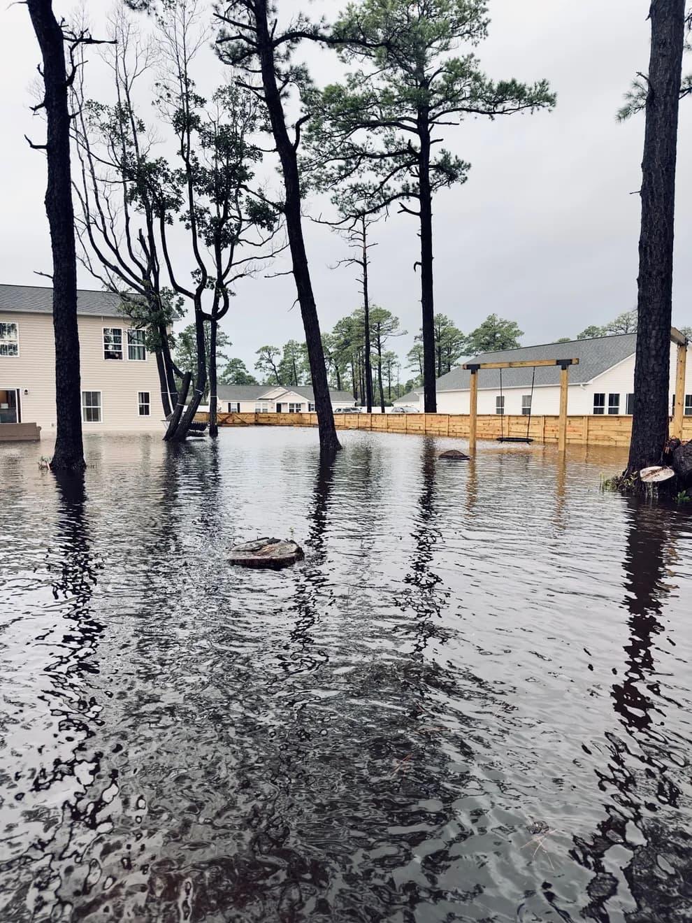 Flood waters encroaching on houses through their backyards