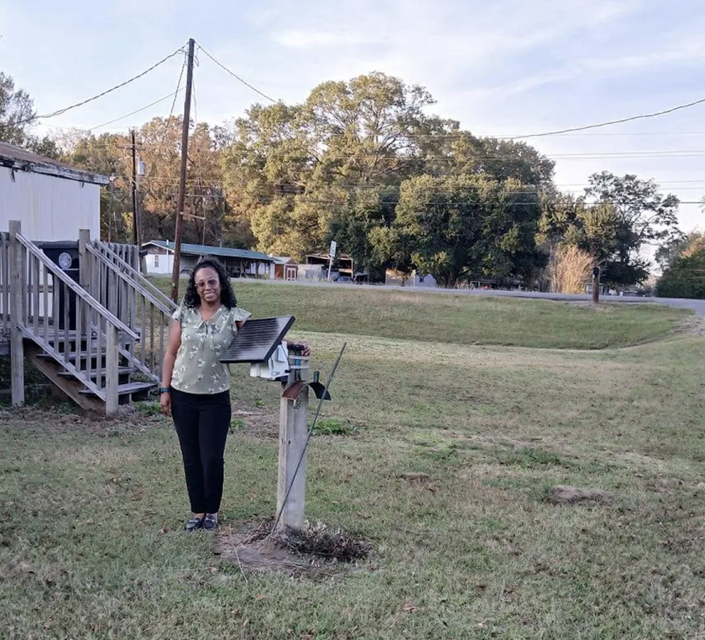 Quisha Reed-Jones standing next to an AirPen device in her front yard