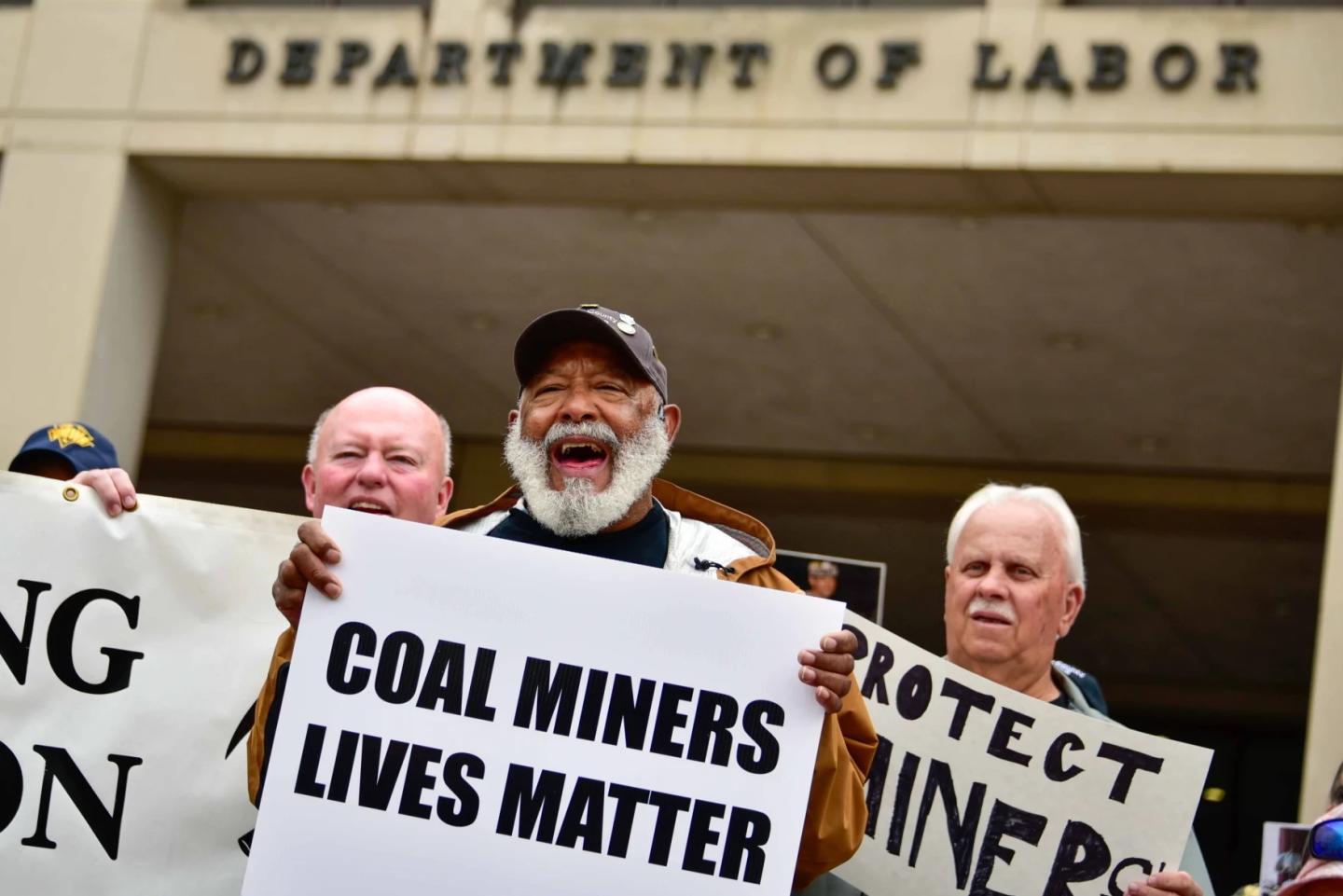 Coal power plant workers holding signs in protest