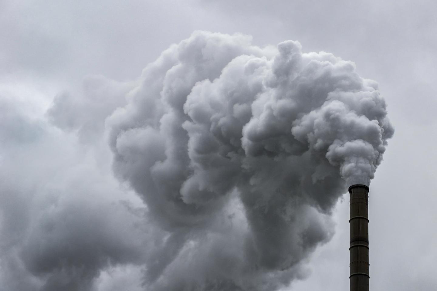 A plume of smoke coming out of a smokestack