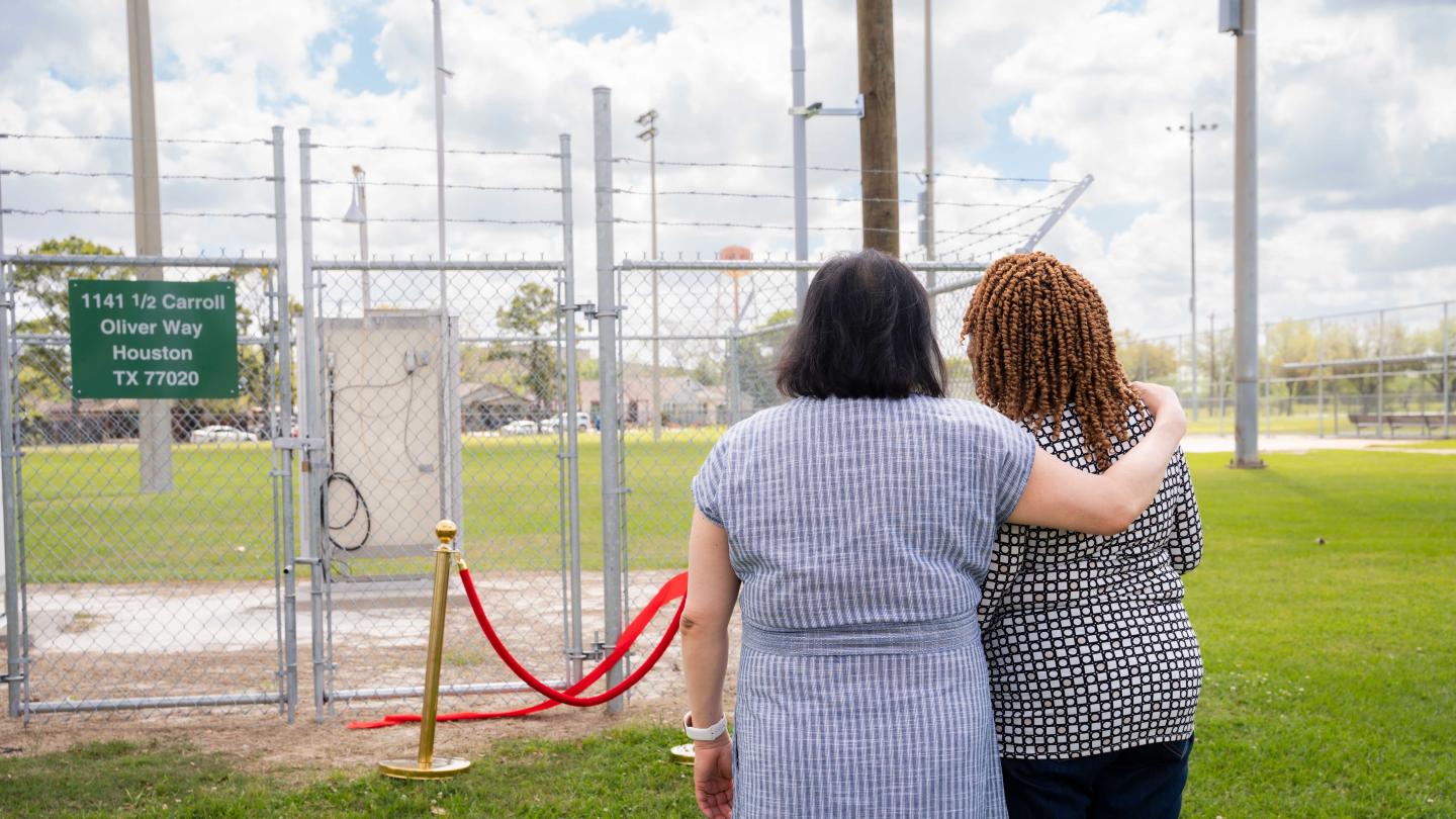 Two people, arms around each other, looking at a newly installed air monitor