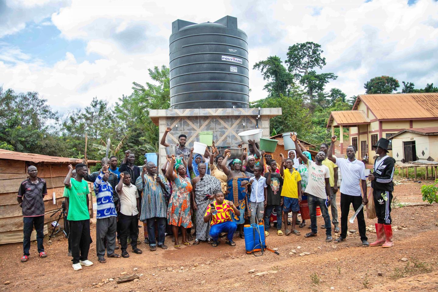 Members of village standing in front of a new water tank