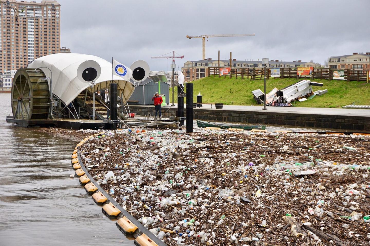 Mr. Trash Wheel, a large trash-eating contraption with googly eyes, about to eat some trash in Baltimore Harbor