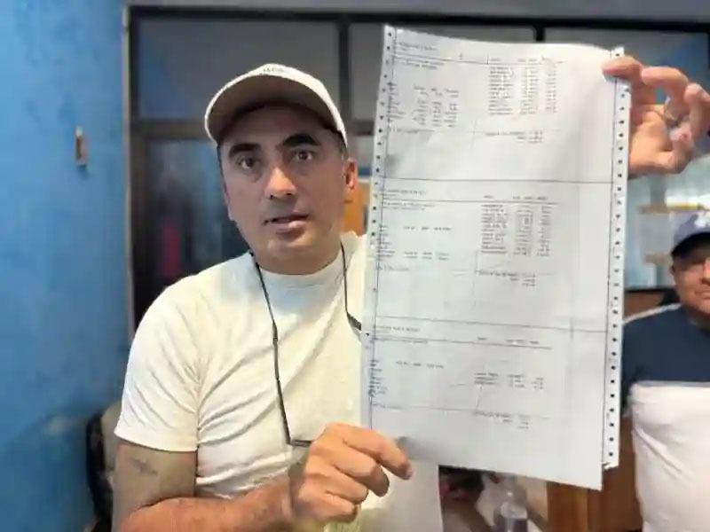 A man holding up a print-out of data regarding a shipment of fish