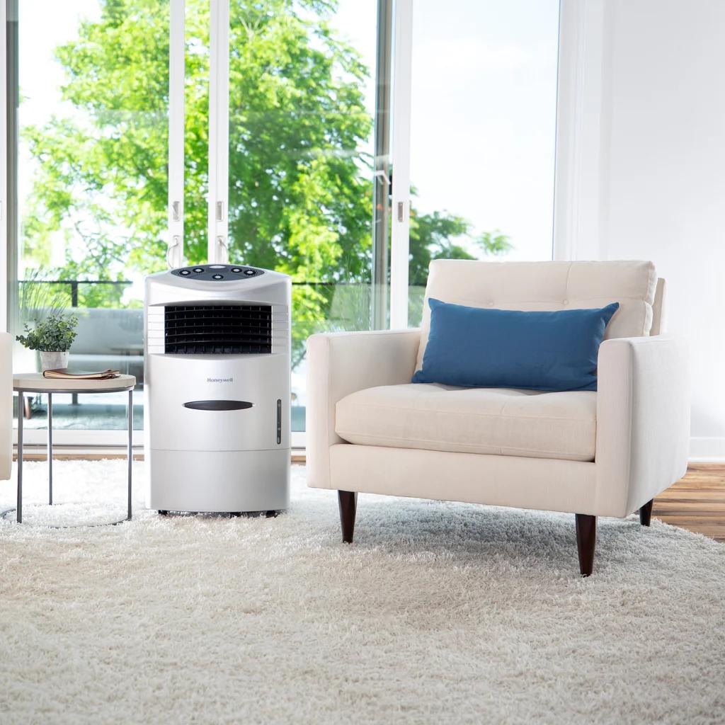 A swamp cooler sitting next to a chair in a living room