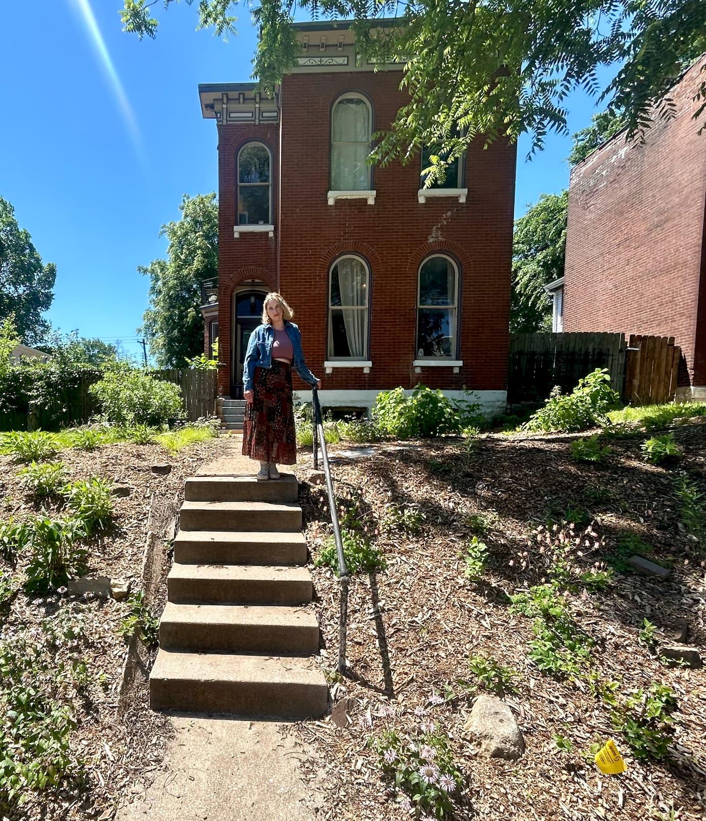 Aubrey Byron standing at the top of her steps in front of her house