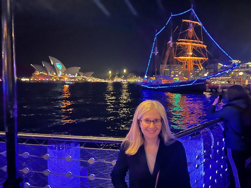Sharon Melamed standing in front of Sydney Harbor at night