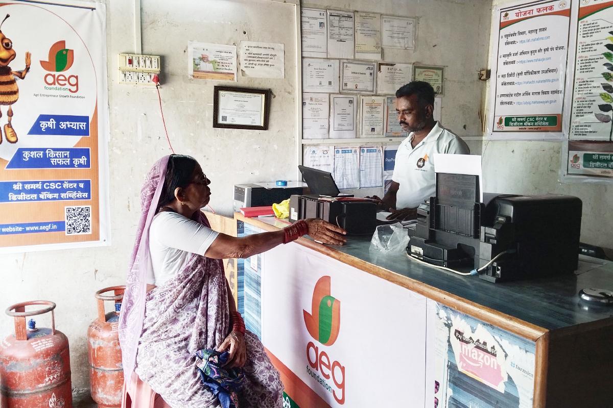 Somnath standing behind the counter while a woman stands in front of him