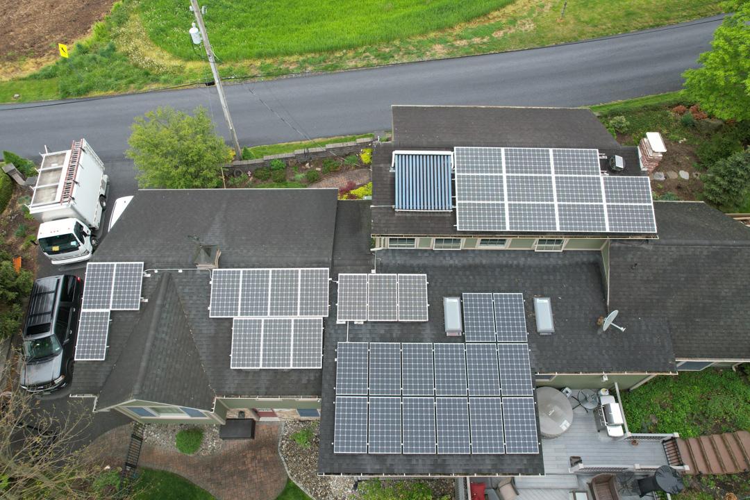An overhead shot of rooftops with solar panels on them