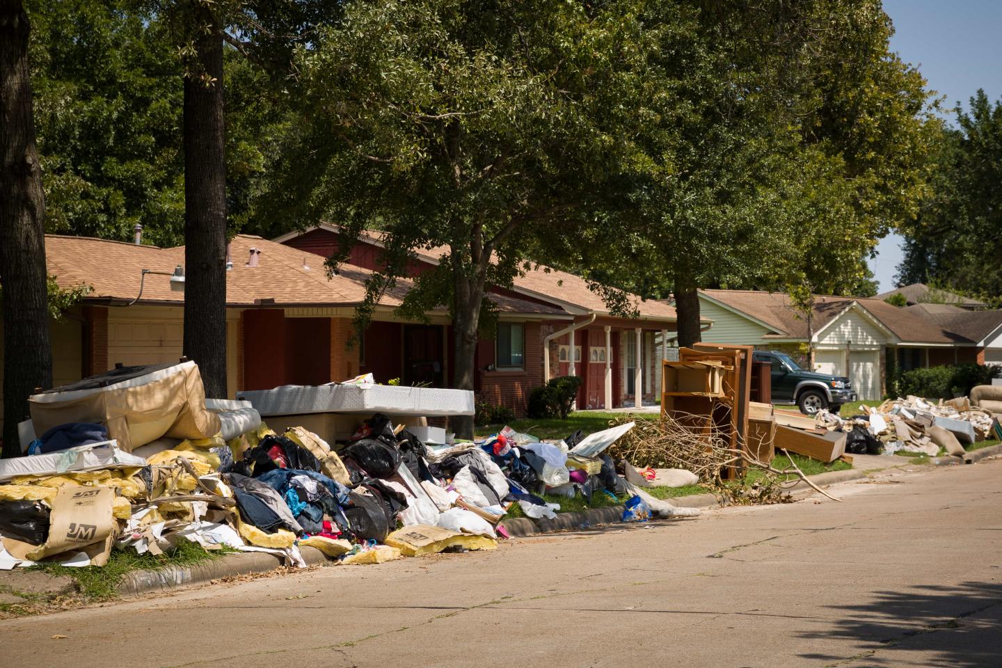Flood-damaged houses and piles of ruined belongings on the street