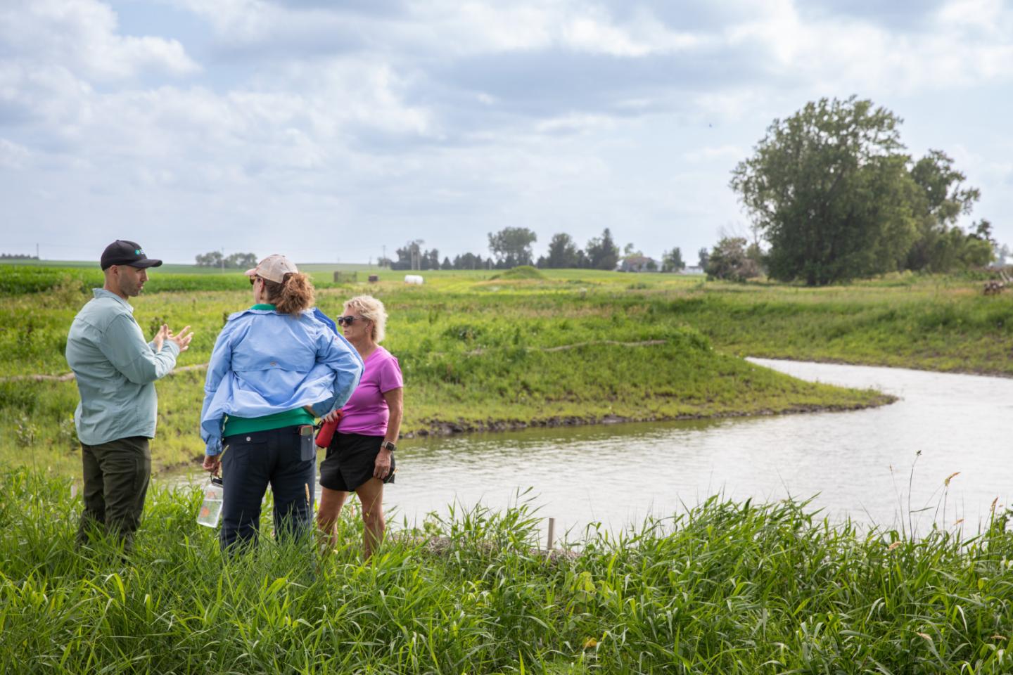Vincent Gauthier talks conservation with Ruth McCabe and Lynn Ohrt near a waterway