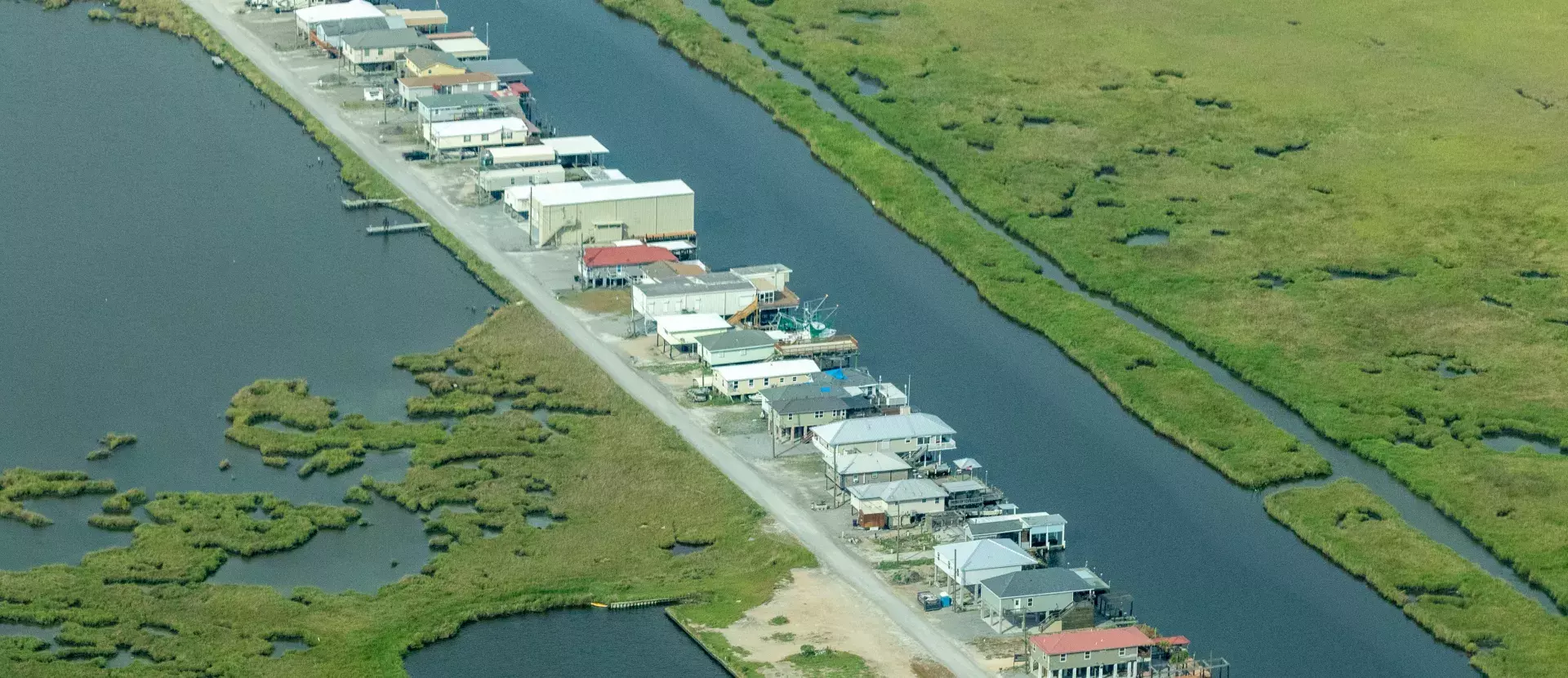 A row of houses in wetlands surrounded by water