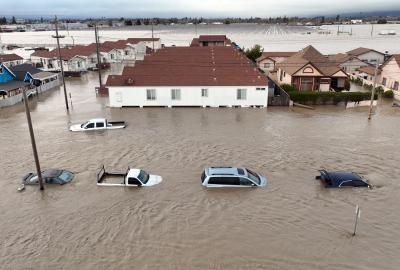 An aerial photograph of cars and homes engulfed by floodwaters