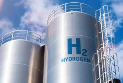 Tall cylindrical steel hydrogen tanks against a blue sky