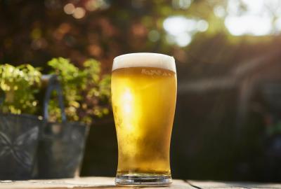 A cool, crisp pint of beer sitting on an outside table