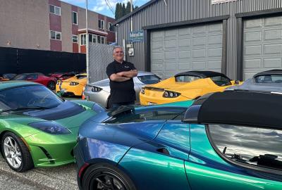 Carl Medlock standing in a row of electric vehicles