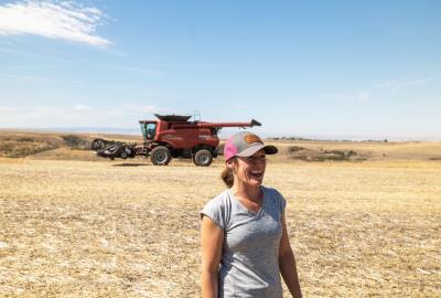 Cori Wittman Stitt standing in front of a combine on her family farm