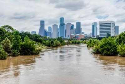 Flooded waters in the foreground with a city skyline in the background