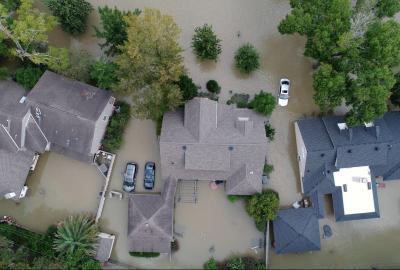 An aerial shot of houses submerged and surrounded by flood waters
