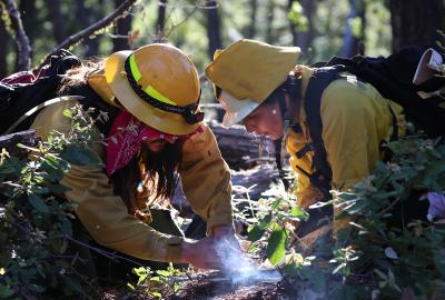 Esak Ordoñez working on a controlled fire with a partner